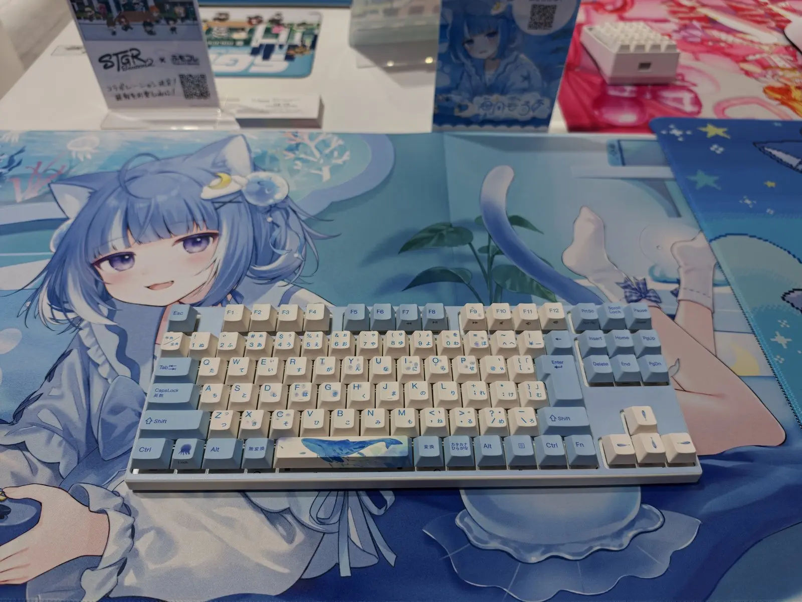 海月雲ろあコラボのキーボード。白と水色のキーキャップ、青い海のデスクマット